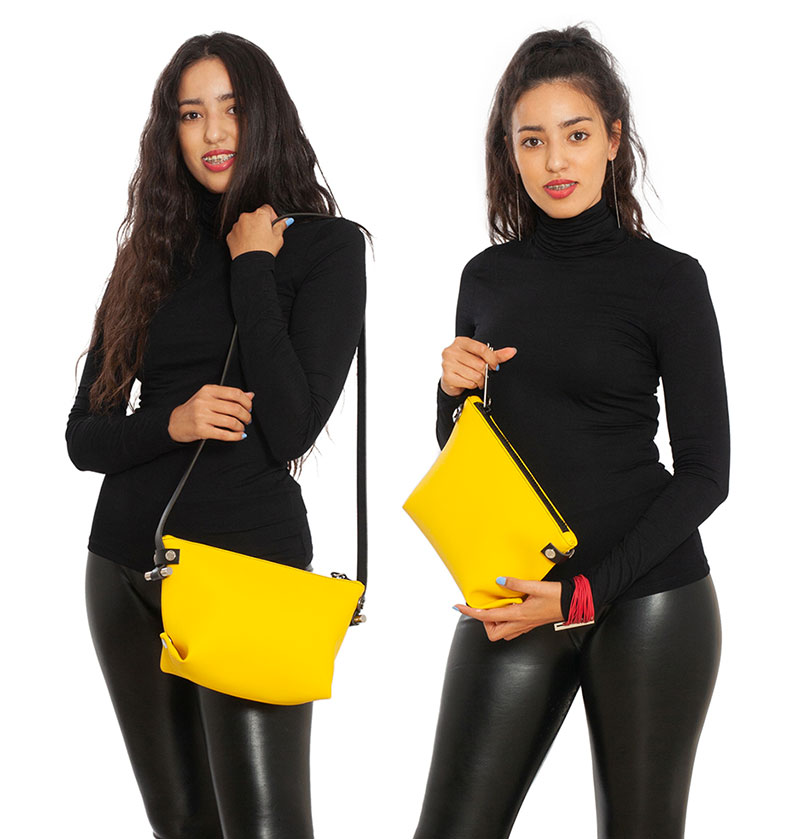 Pochette in pelle riciclata giallo simile DAMPAÌ, indossata da modello Pochette trasformabile La POUCH & TRACOLLA in pelle riciclata colore giallo smile DAMPAÌ , con tracolla rimovibile, indossata da modello.